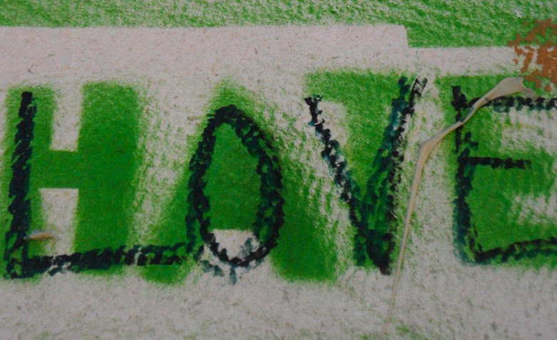Auf einer weißen Wand steht in Grün das Wort „Hate“, in schwarz wurde darüber das Wort „Love“ geschrieben.