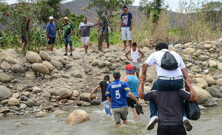 Eine Gruppe Venezolaner überquert den Grenzfluss Río Táchira an der kolumbianischen Grenze.